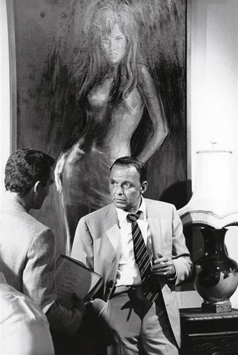 Frank Sinatra standing beneath a portrait of Raquel Welch in Miami, 1968 