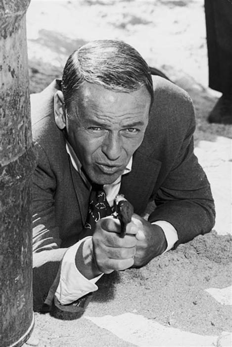 Frank Sinatra  by Terry O'Neill shooting a gun 1960